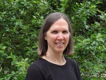 photo of woman in front of leaves