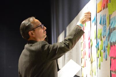 man putting post-it note on wall