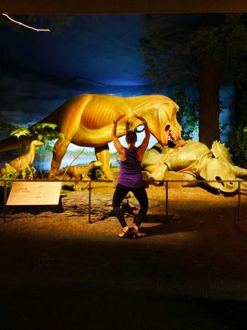 woman doing ballet in front of dinosaur exhibit
