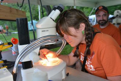 woman looking through microscope