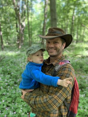 man in hat carrying baby