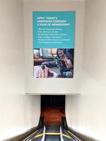 poster hanging in escalator hall
